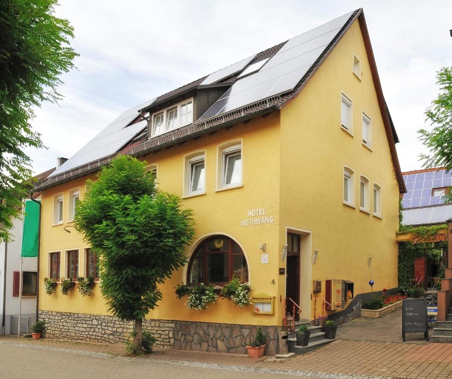Sindringen奴斯旺酒店的屋顶上设有太阳能电池板的黄色房子