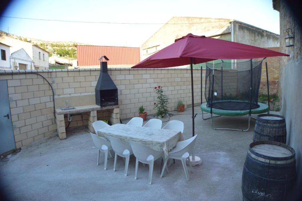 巴尔铁拉Casa Rural El Convento的庭院配有桌椅和遮阳伞。