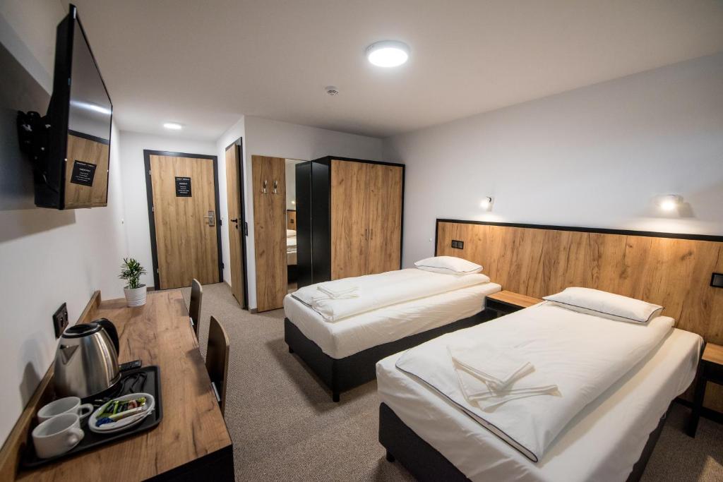 斯巴拉Sport Rooms Spała的酒店客房配有两张床和一张书桌