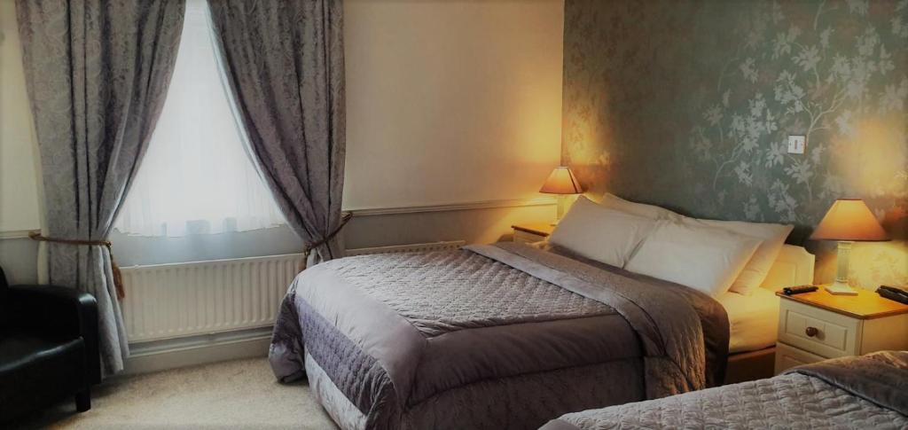 康镇Danagher’s Hotel Cong的酒店客房设有两张床和窗户。