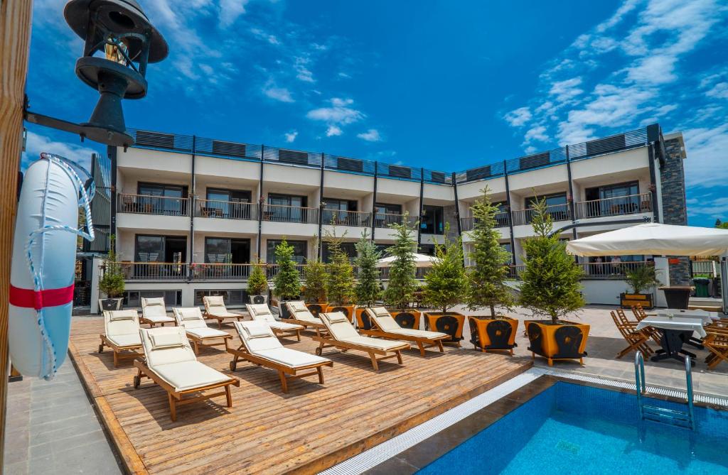 切什梅Kosa Otel Çeşme的酒店庭院设有椅子和游泳池