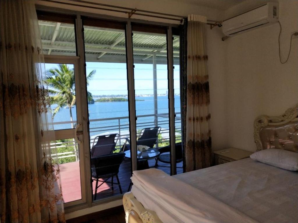 苏瓦Suva Hideaway Villa的一间卧室配有一张床,享有海景