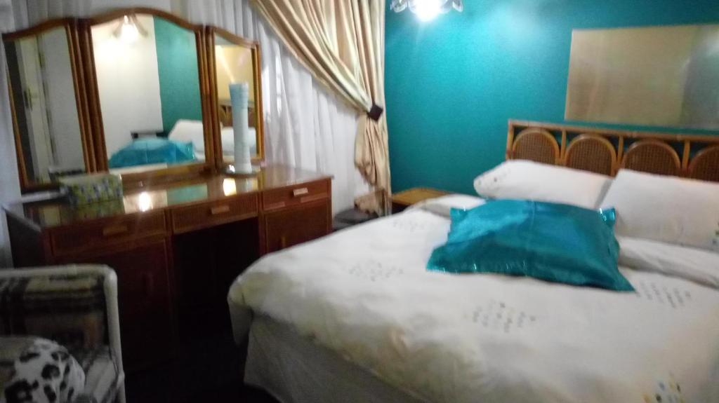 VerulamNonkululeko Accommodation 2的一间卧室配有一张带梳妆台和镜子的床