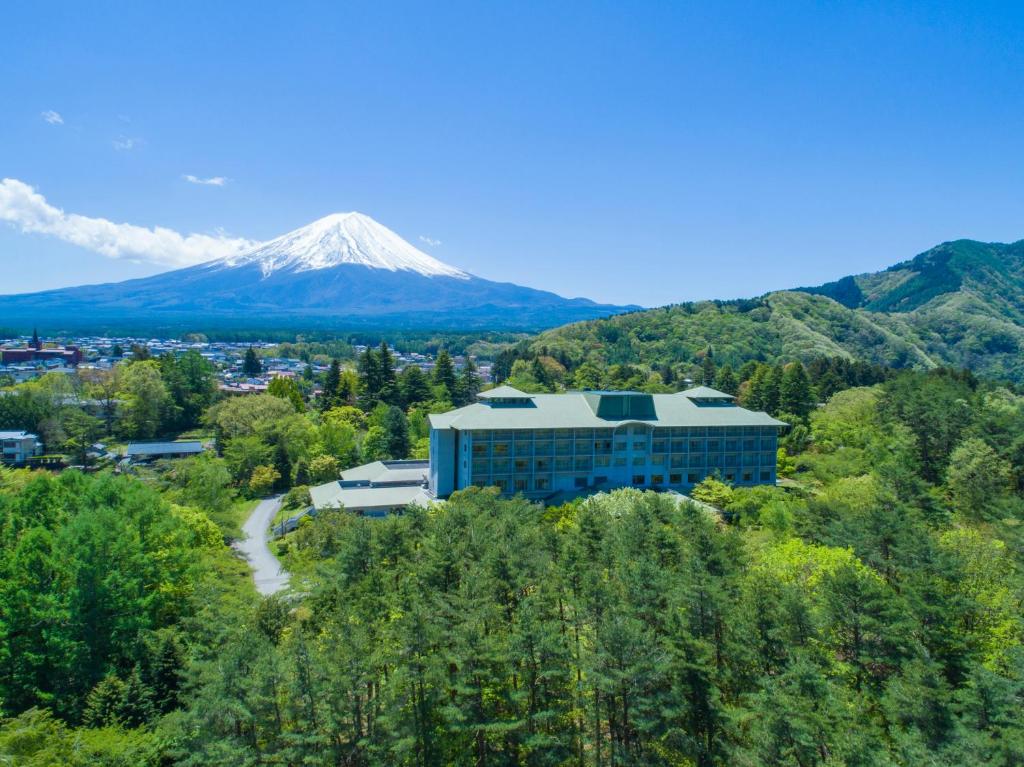 富士河口湖富士豪景酒店的山丘上的建筑,背景是山
