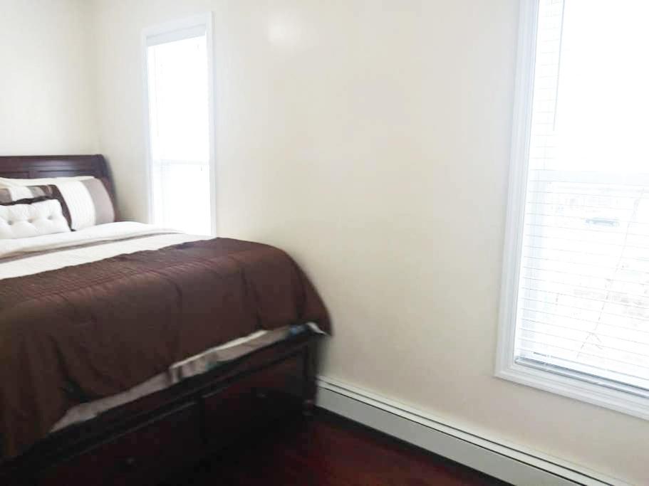 布鲁克林Rochester's Place的一间卧室设有一张床和一个窗口