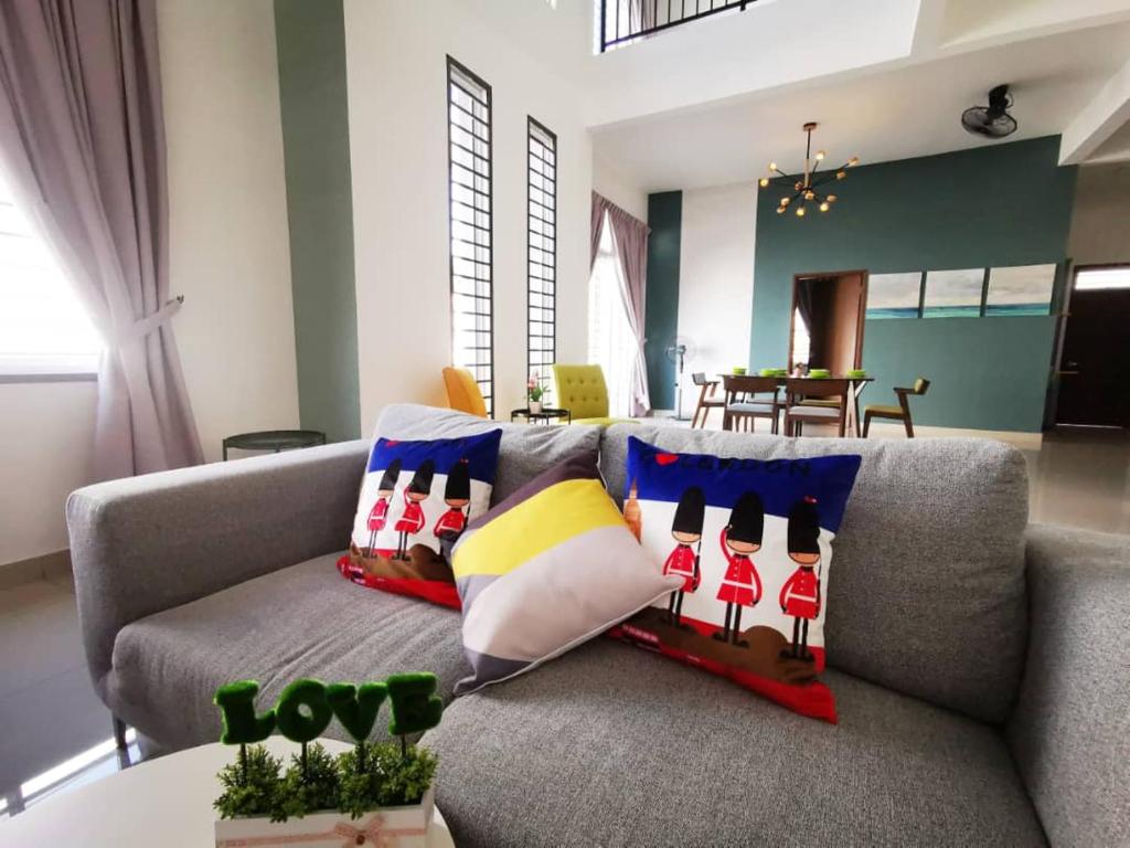 迪沙鲁Desaru Homestay by Home Cube的客厅配有带色彩缤纷枕头的灰色沙发