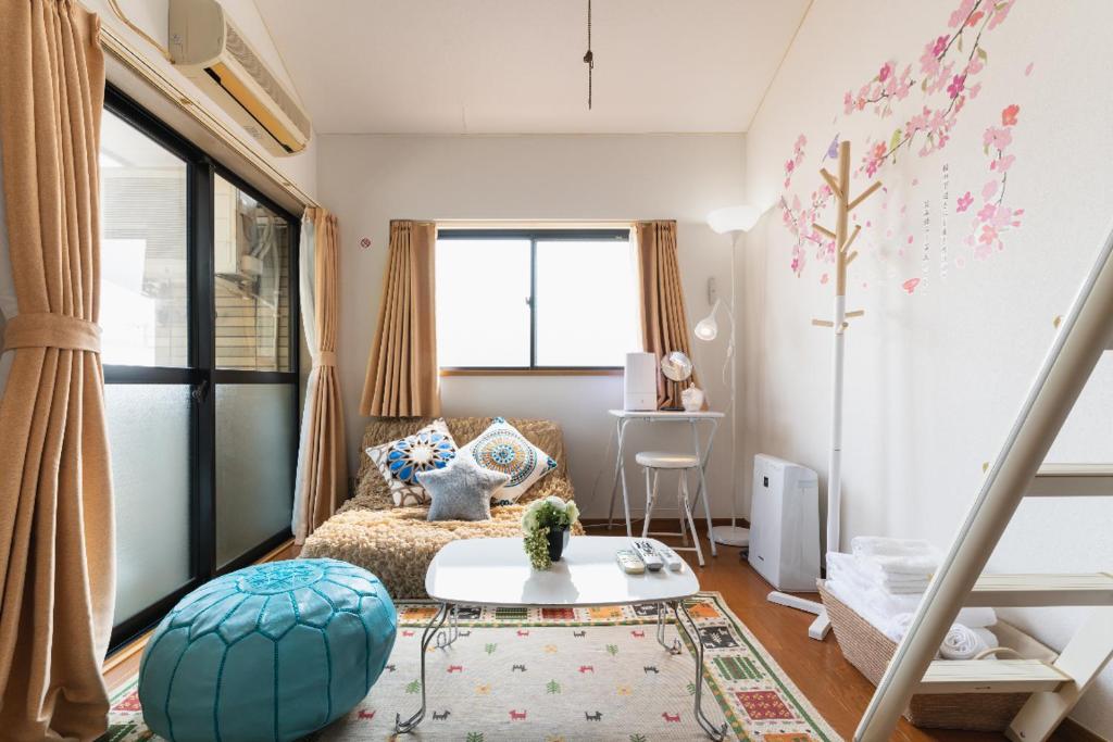 福冈ROOMs六本松03的一个小客厅,配有一张床和一张桌子