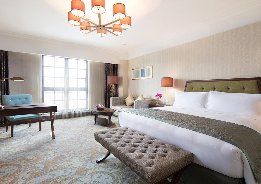 杭州杭州丽晶美庐酒店的配有一张大床和一架钢琴的酒店客房