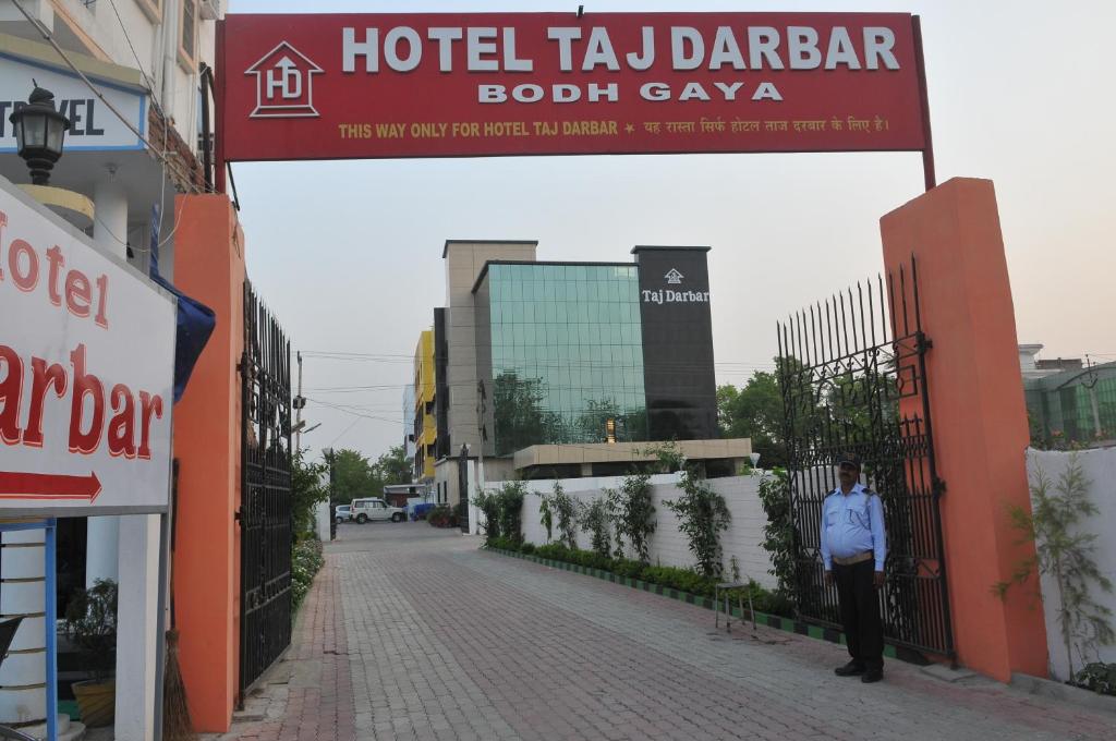 菩提伽耶Hotel Taj Darbar的站在塔贾贾多蒂酒店前的街道上的人