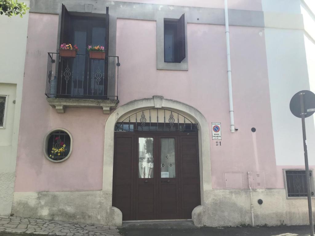 韦列Dimora San Biagio的粉红色的建筑,设有门和阳台