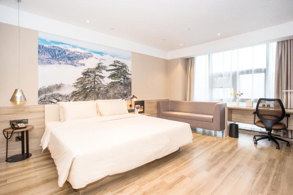 合肥合肥高新区创新产业园亚朵酒店的卧室配有一张白色大床和一张书桌