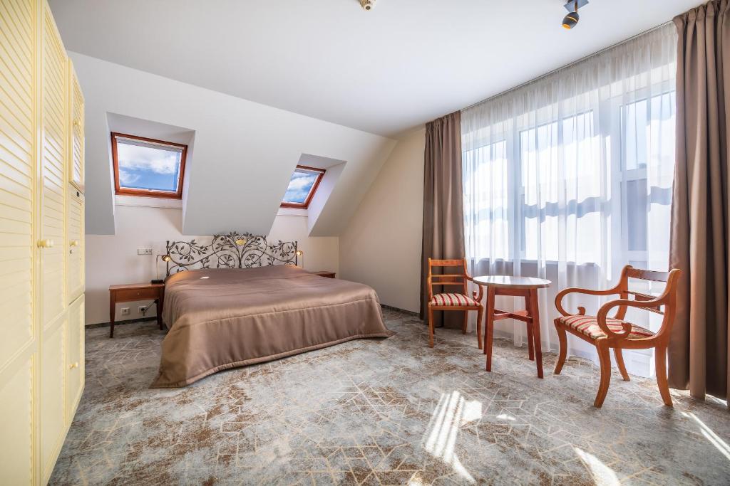 帕兰加Vila Ieva的卧室配有一张床和一张桌子及椅子
