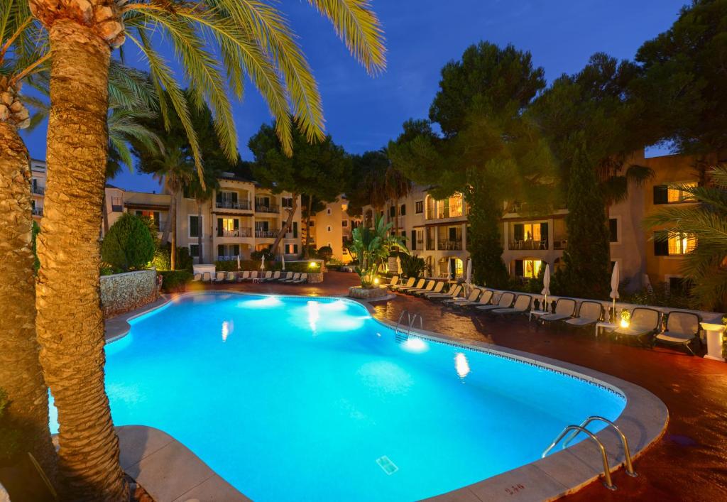 卡拉郫公寓奥纳卡拉皮俱乐部公寓酒店的一座棕榈树和建筑的游泳池