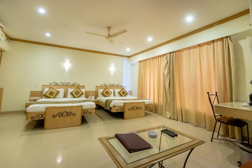 孟买花园酒店的酒店客房设有两张床和一张桌子。