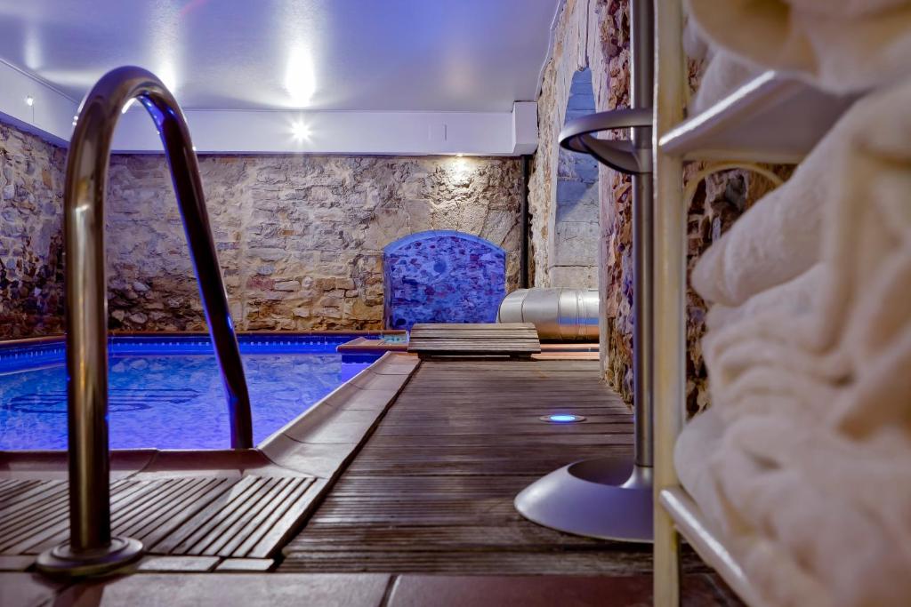 里昂格兰德酒店的客房设有带木地板和椅子的游泳池。