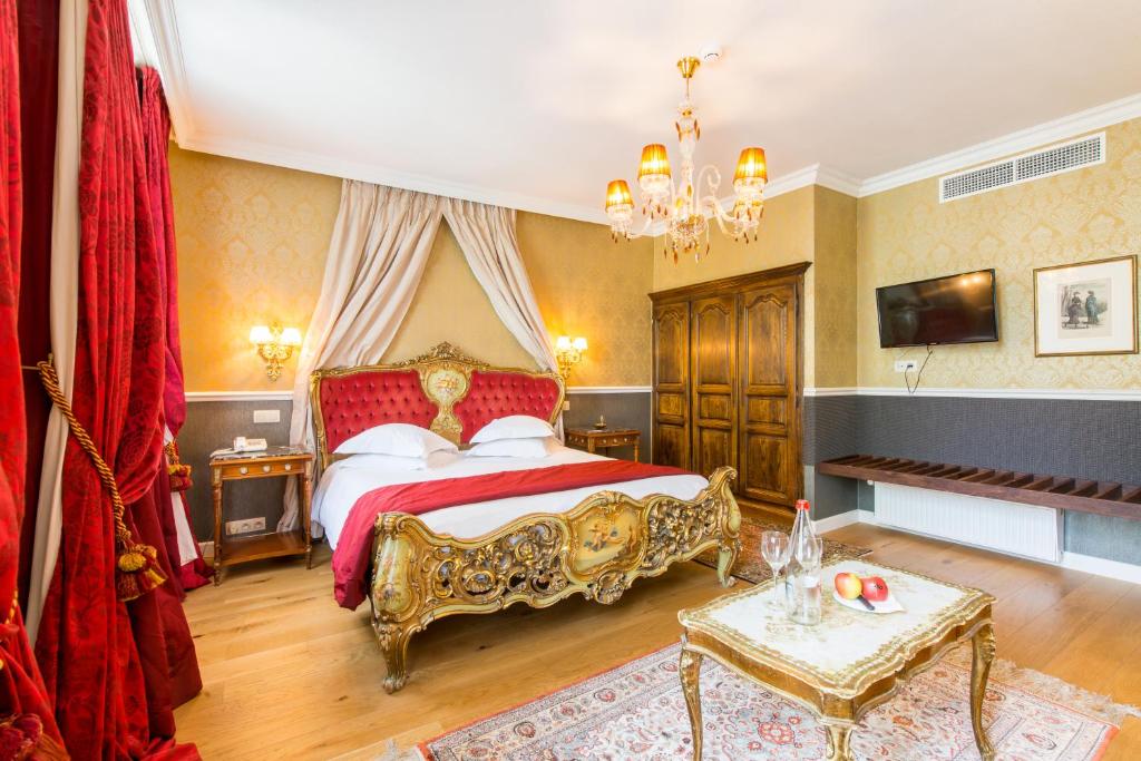 布鲁日Boutique Hotel Die Swaene的一间卧室配有一张大床,配有红色和金色家具