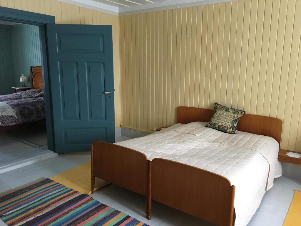 灵厄比Skjeggestad Gjestehus的一间卧室配有一张床和一个蓝色的门