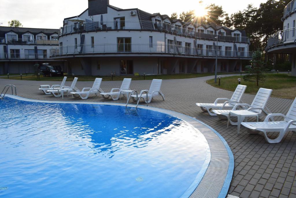 波别罗沃Apartament Silence Baltic Wenecja的一个带躺椅的游泳池和一个背景建筑