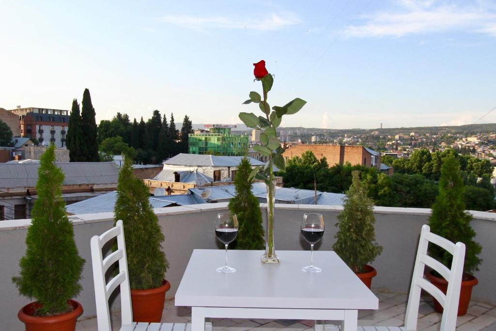 第比利斯Apart-hotel TARHUN的阳台上的白色桌子和两杯葡萄酒