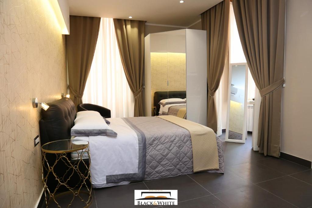 那不勒斯Residence Black & White的酒店客房,配有床和镜子