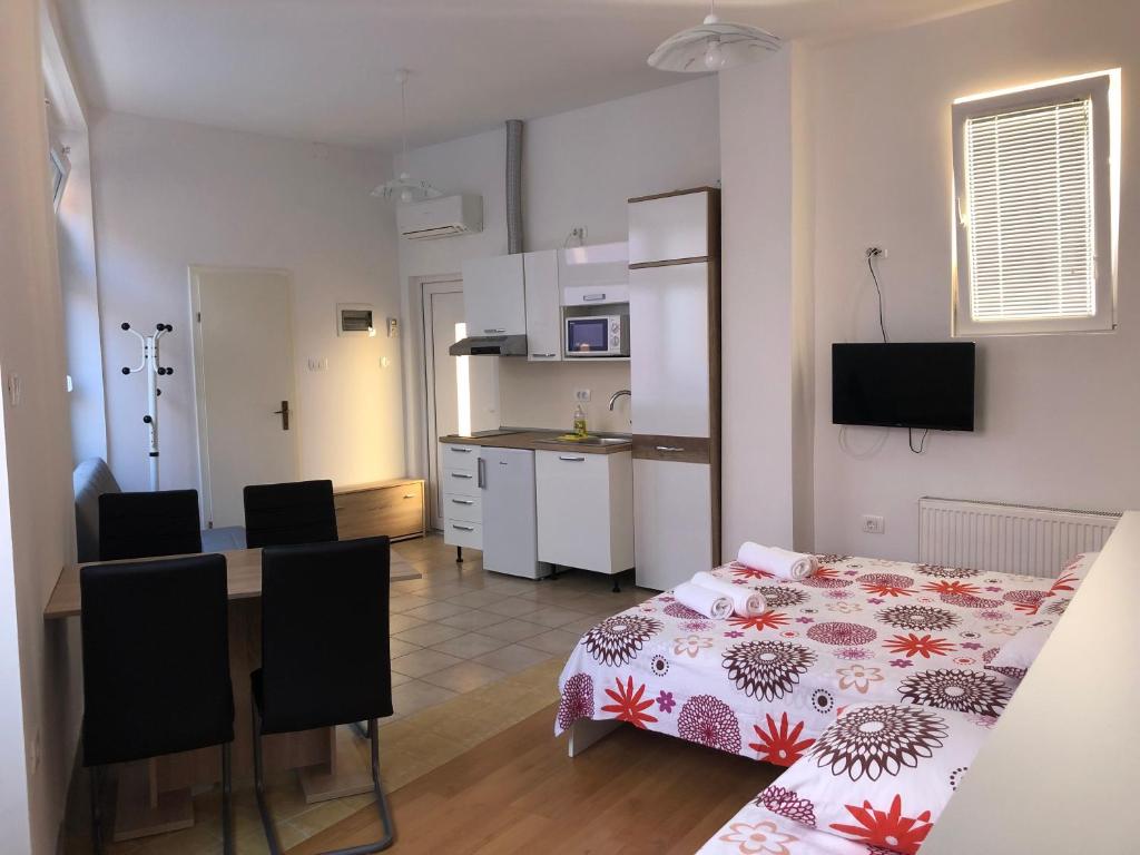 伊佐拉Apartments & Rooms Nardin的客房设有厨房和带床的桌子。
