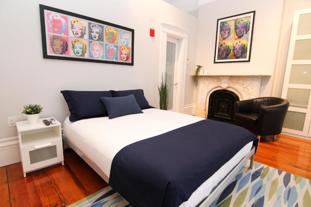 波士顿Charming & Stylish Studio on Beacon Hill #8的一间卧室配有一张床、一把椅子和一个壁炉