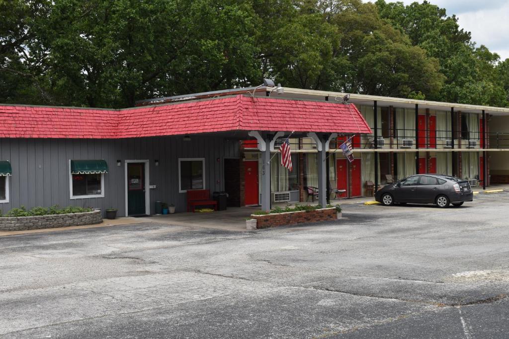 尤里卡斯普林斯Thurman's Lodge的停在一座红色屋顶建筑前面的汽车
