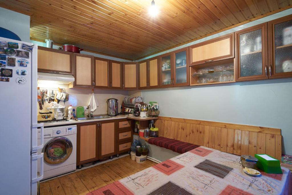 LahıcAncient Lahij Guest House的厨房配有木制橱柜、炉灶和冰箱。