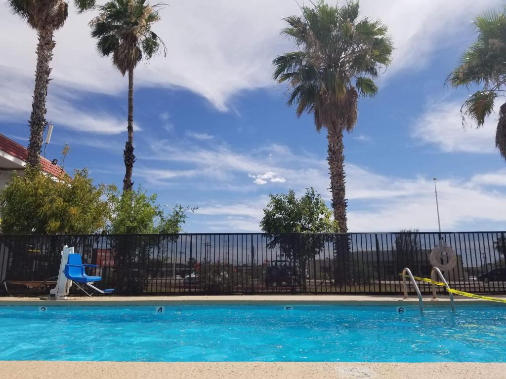 土桑Minsk Hotels - Extended Stay, I-10 Tucson Airport的一座棕榈树和围栏的游泳池
