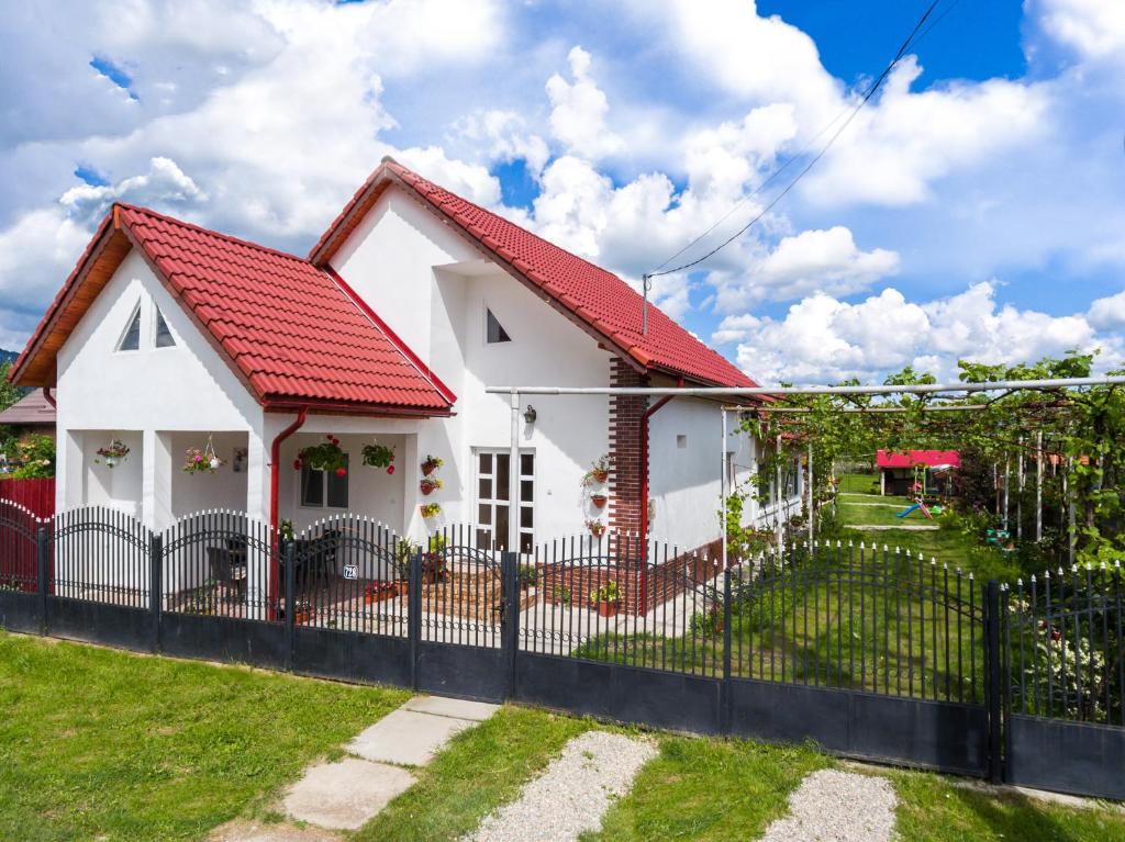 巴亚德菲耶尔Casa de vacanta Marya的白色的房子,有红色的屋顶和栅栏