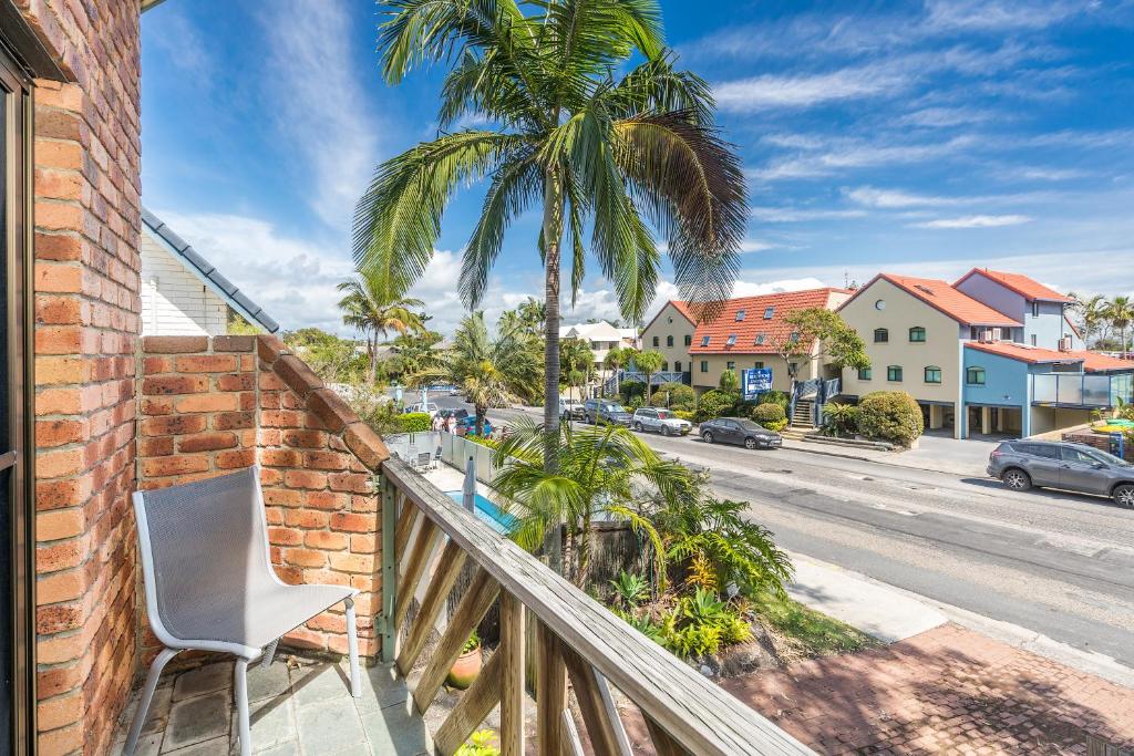 拜伦湾Byron Bay Accom - Balcony on Lawson的阳台配有椅子和街道上的棕榈树
