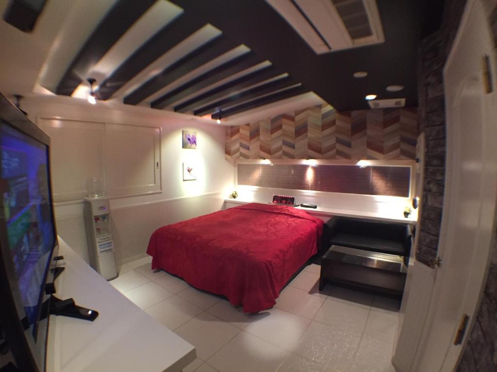 磐城HOTEL KAZAN (Adult Only)的一间在房间内配有红色床的卧室