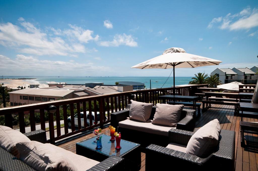 伊丽莎白港科尔威酒店的阳台配有沙发和遮阳伞,海滩