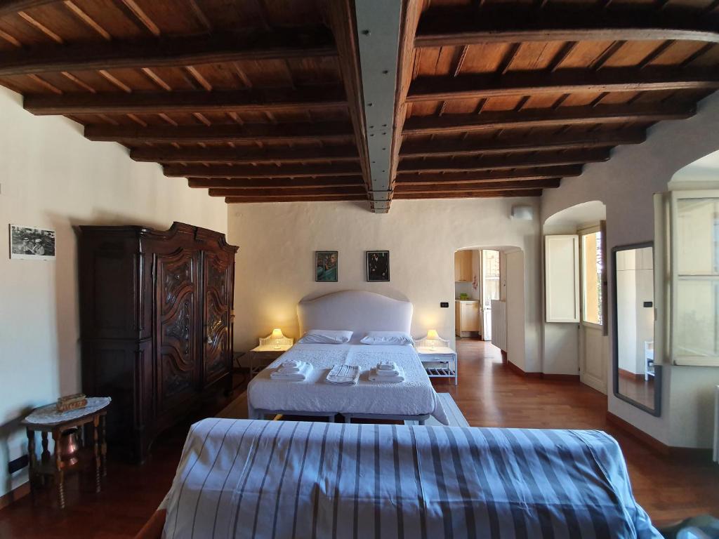 都灵Palatina apartment的一间大型卧室,配有两张床和木制天花板
