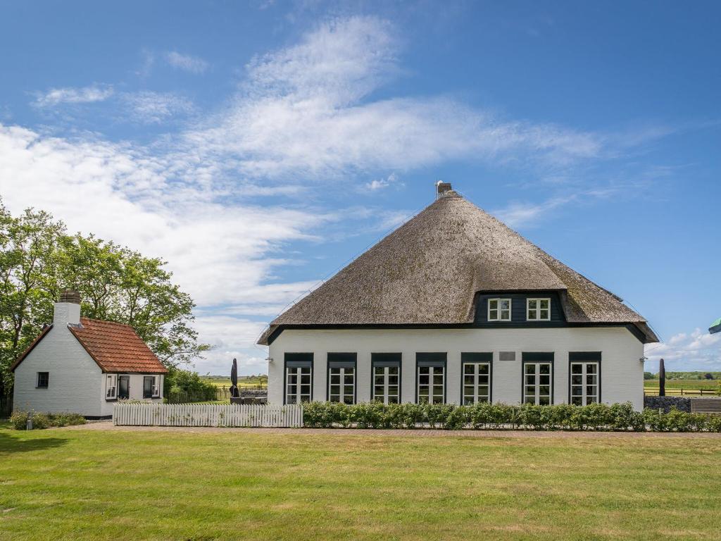 德科克斯多普Spacious Farmhouse in Dutch coast Texel with Garden的一座带茅草屋顶的大型白色房屋