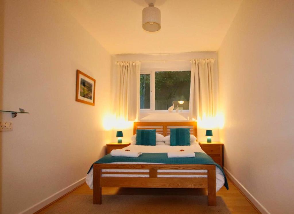 查尔斯敦Porthpean Apartment的一间卧室配有一张带蓝色枕头的床和一扇窗户。