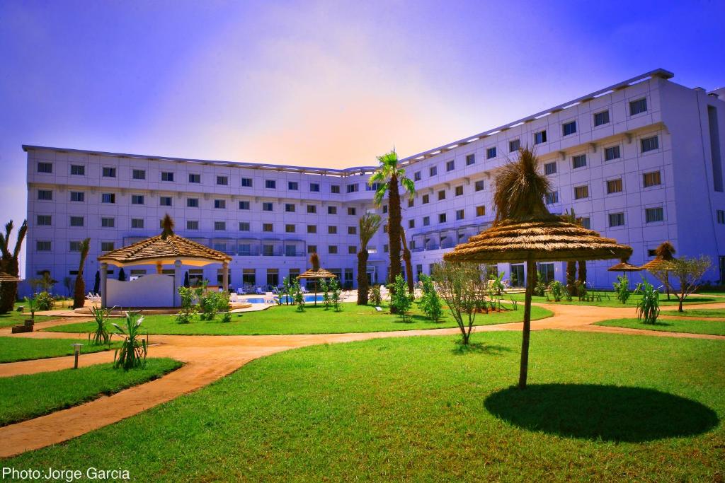诺阿瑟Relax Hotel Airport Nouasseur的前面有草坪的白色大建筑