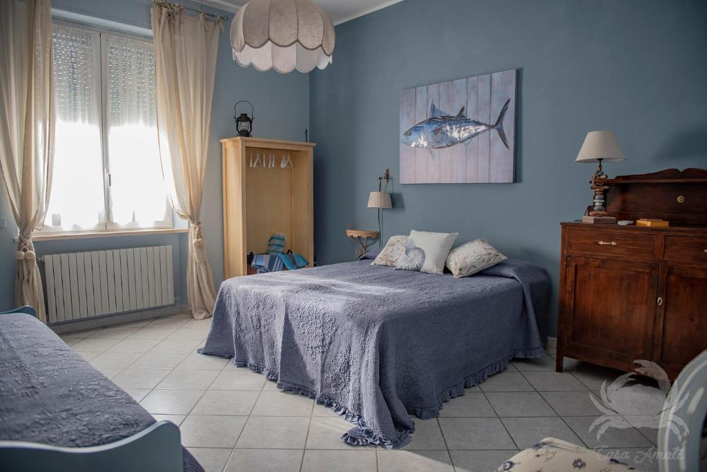 圣温琴佐Casa Amati - Sea house apartments的一间蓝色的卧室,配有一张床,墙上挂着一幅鱼画