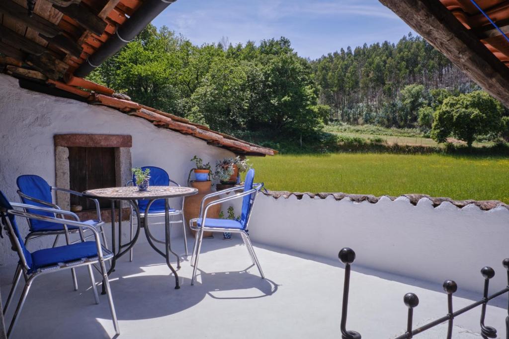 波亚里什新镇A Charming , Traditional Cottage at Quinta da Ribeira的一个带桌椅和墙壁的庭院