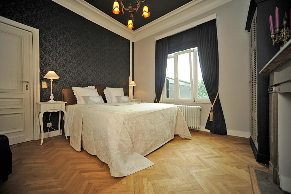 根特世博13号住宿加早餐旅馆的一间卧室设有一张大床和一个窗户。