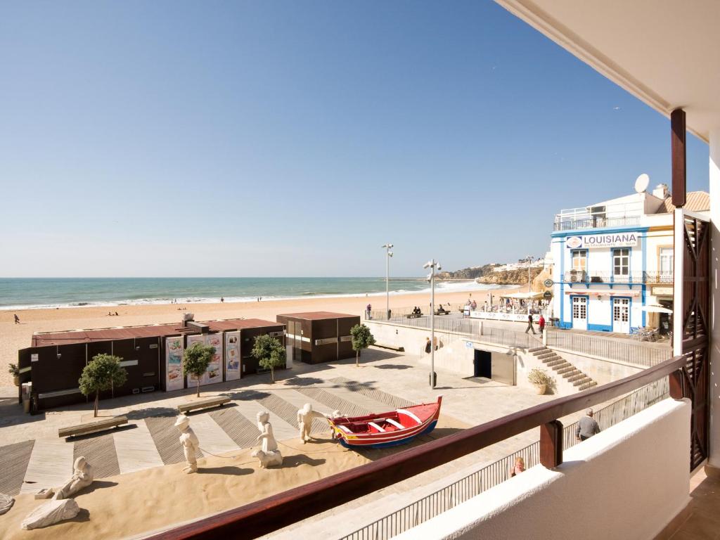 阿尔布费拉Apartamentos Edificio Albufeira - Alojamento Local的从大楼的阳台上可欣赏到海滩景色