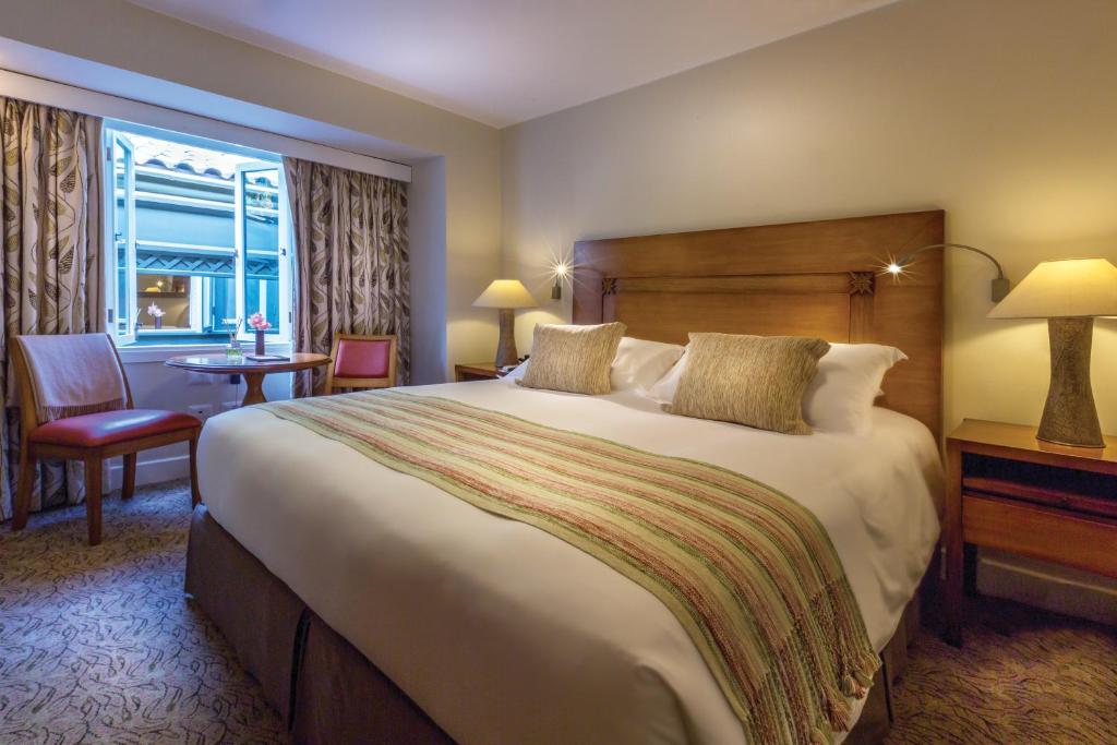 马丘比丘Sanctuary Lodge, A Belmond Hotel, Machu Picchu的一间设有大床和窗户的酒店客房