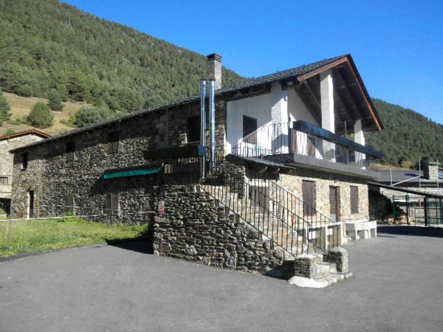 马萨纳Borda Cortals de Sispony的一座石头建筑,旁边设有阳台