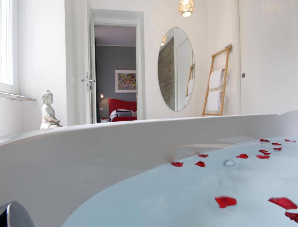 罗马阿穆尔B&B酒店的浴室设有镜子和铺有红色花卉的浴缸,地板上