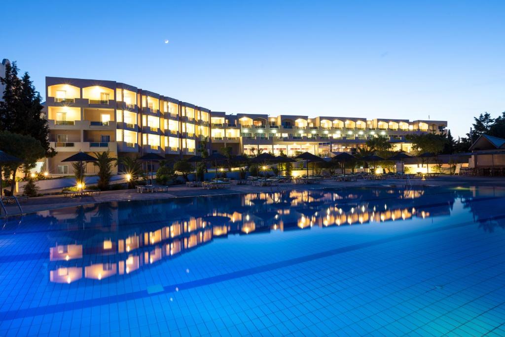 卡尔扎迈纳君主海滩酒店的一座大楼前的游泳池