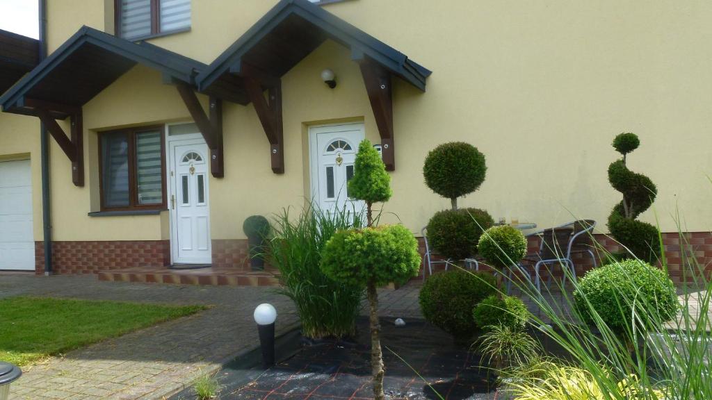 米奇科夫采Apartament Bieszczady的一座房子,有一道白色的门和一些灌木丛