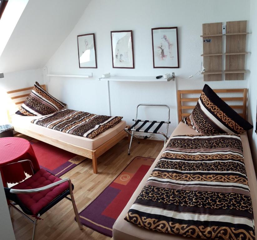 纽伦堡Zwei ruhige, private Gästezimmer nahe U-Bahn的一间设有两张床和椅子的房间