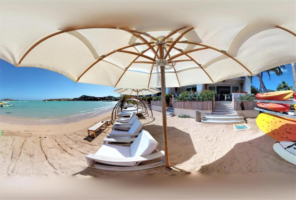 古斯塔维亚昂迪尼斯海滩酒店的海滩上摆放着一排椅子和一把遮阳伞