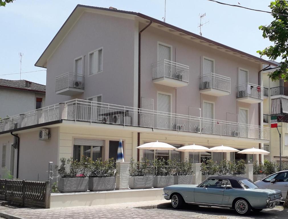 切塞纳蒂科B&b villa lambusta的停在大楼前的蓝色汽车,有雨伞