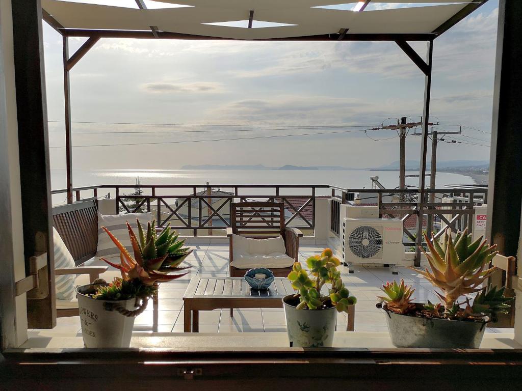 科林瓦里奥Sandy's Home的阳台种植了盆栽植物,配有桌子